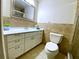 Updated bathroom features a white vanity with drawers, framed mirror, and tile walls at 250 Rosery Nw Rd # 218, Largo, FL 33770