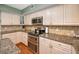 Spacious kitchen featuring stainless steel oven and microwave plus granite countertops at 250 Rosery Nw Rd # 218, Largo, FL 33770