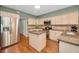 Bright kitchen with stainless steel appliances, center island, tile backsplash and hardwood floors at 250 Rosery Nw Rd # 218, Largo, FL 33770