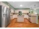 Bright kitchen with stainless steel refrigerator, wood floors, and granite countertops at 250 Rosery Nw Rd # 218, Largo, FL 33770