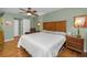 Bedroom featuring hardwood floors, a large bed, and an ensuite at 250 Rosery Nw Rd # 218, Largo, FL 33770
