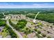 An aerial view of a neighborhood featuring a home near a pond and lush green landscaping at 31108 Whitlock Dr, Wesley Chapel, FL 33543