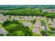 An aerial view shows the homes and community nestled among wooded areas and ponds at 31108 Whitlock Dr, Wesley Chapel, FL 33543