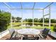 Screened patio with outdoor dining set and views of the pond and surrounding landscape at 31108 Whitlock Dr, Wesley Chapel, FL 33543
