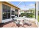 Enclosed patio area with a glass table and seating surrounded by lush greenery and privacy screening at 31108 Whitlock Dr, Wesley Chapel, FL 33543