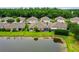 Manicured backyards of single-story homes overlook a serene pond with a lush green forest backdrop at 31108 Whitlock Dr, Wesley Chapel, FL 33543