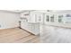 Bright, modern kitchen featuring white cabinets, stainless steel appliances, and light wood-look flooring, flowing into the living area at 315 Dorchester Dr, Venice, FL 34293