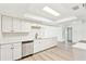 Well-lit kitchen with stainless steel dishwasher, white cabinetry, and wooden flooring, offering style and functionality at 315 Dorchester Dr, Venice, FL 34293