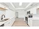 Open-concept kitchen with stainless steel appliances, quartz countertops, and wood-look floors, creating a bright and airy space at 315 Dorchester Dr, Venice, FL 34293