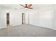 Carpeted main bedroom featuring a ceiling fan, two closets, and entrances to the bathroom and another room at 315 Dorchester Dr, Venice, FL 34293