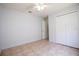 This inviting bedroom features tile flooring, a ceiling fan, and closet, perfect for relaxation and organization at 3201 Pine Top Dr, Valrico, FL 33594