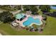 Aerial view of a community pool with ample lounge seating and a covered picnic area, surrounded by a tall white fence at 3201 Pine Top Dr, Valrico, FL 33594