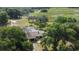 Aerial view of the property featuring mature trees, a pool, and lush greenery in a serene environment at 34389 Orchid Pkwy, Ridge Manor, FL 33523