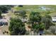 An aerial shot showing the home nestled among mature trees and a spacious yard, close to a serene lake at 34389 Orchid Pkwy, Ridge Manor, FL 33523