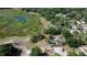 Aerial perspective of a home surrounded by trees, featuring a pool, a nearby lake, and expansive outdoor space at 34389 Orchid Pkwy, Ridge Manor, FL 33523