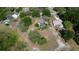 Overhead view of the home showcasing the pool, surrounding trees, and neighboring houses in a peaceful setting at 34389 Orchid Pkwy, Ridge Manor, FL 33523