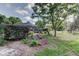 Sprawling backyard with mature trees, screened-in lanai, and well-manicured lawn at 34389 Orchid Pkwy, Ridge Manor, FL 33523