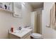 Simple bathroom with a single sink vanity, toilet, mirror, and shower/tub combination with a shower curtain at 34389 Orchid Pkwy, Ridge Manor, FL 33523