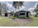 Charming one-story home featuring a well-maintained yard with mature trees, a front porch, and an attached garage at 34389 Orchid Pkwy, Ridge Manor, FL 33523