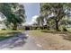 Ranch-style home with an attached garage, mature landscaping, and large trees at 34389 Orchid Pkwy, Ridge Manor, FL 33523