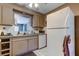 Functional kitchen featuring white appliances, tile backsplash, and generous cabinet storage at 34389 Orchid Pkwy, Ridge Manor, FL 33523