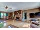 Spacious living room with hardwood flooring, a brick fireplace, and a connecting dining area at 34389 Orchid Pkwy, Ridge Manor, FL 33523