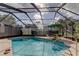 Relaxing screened-in pool area with lounge chairs and shade umbrella at 34389 Orchid Pkwy, Ridge Manor, FL 33523