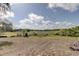 A vast open field with native Florida foliage with sunny skies and puffy clouds in a natural and serene environment at 34389 Orchid Pkwy, Ridge Manor, FL 33523
