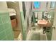 Retro bathroom features green tiles, a pink sink, and ample storage space at 406 2Nd Sw St, Ruskin, FL 33570