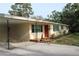 Inviting single-story home with a quaint red door and convenient carport at 406 2Nd Sw St, Ruskin, FL 33570