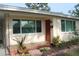 Close-up of a home entrance with a red door, tiled porch, and decorative plants at 406 2Nd Sw St, Ruskin, FL 33570