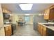 Galley kitchen with stainless steel appliances, light wood cabinets, and adjacent dining area at 406 2Nd Sw St, Ruskin, FL 33570