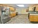 Spacious kitchen featuring wooden cabinets, stainless steel refrigerator, and modern appliances at 406 2Nd Sw St, Ruskin, FL 33570
