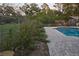 Backyard pool features brick pavers and mature landscaping surrounded by a chain link fence at 406 2Nd Sw St, Ruskin, FL 33570