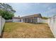 Rear exterior view of house and patio with large yard and privacy fence at 4435 Sail Dr, New Port Richey, FL 34652