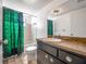 This bathroom has a tub, toilet, vanity with a sink, and an intricate green shower curtain at 4435 Sail Dr, New Port Richey, FL 34652