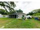 Home's backyard features a screened in patio, mature trees, and boat on trailer at 4657 Parkway Blvd, Land O Lakes, FL 34639