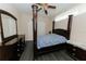 Cozy bedroom featuring a four poster bed, ceiling fan and dark wood furniture at 4657 Parkway Blvd, Land O Lakes, FL 34639