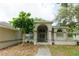 Charming home featuring an arched entryway, double doors, and manicured landscaping at 4657 Parkway Blvd, Land O Lakes, FL 34639