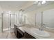 En-suite bathroom features dual sinks, a large mirror, and a walk-in shower at 5024 Sylvester Loop, Tampa, FL 33610