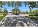 Gated community entrance featuring lush greenery, brick columns, and an iron fence at 5024 Sylvester Loop, Tampa, FL 33610