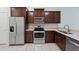 Kitchen area with stainless steel appliances, dark wood cabinets, and tile backsplash at 5024 Sylvester Loop, Tampa, FL 33610