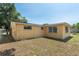 Backyard of a yellow house, with a lawn and a chain-link fence at 5027 Overton Dr, New Port Richey, FL 34652