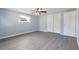 A bedroom with light blue walls, a ceiling fan, gray floors and a closet with white bi-fold doors at 5027 Overton Dr, New Port Richey, FL 34652
