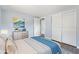 Staged bedroom with closet, modern ceiling fan and grey wood floors at 5027 Overton Dr, New Port Richey, FL 34652