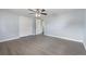 Spacious bedroom with ceiling fan, closet and grey wood floors at 5027 Overton Dr, New Port Richey, FL 34652