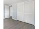 A bedroom with light blue walls, gray floors, and a closet with large white bi-fold doors at 5027 Overton Dr, New Port Richey, FL 34652