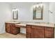 A dual vanity bathroom with granite counters, framed mirrors, wood cabinets, and tile floors at 511 Roanoke St, Dunedin, FL 34698