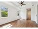 Spacious bedroom with wood floors, many windows providing lots of natural light and a ceiling fan at 511 Roanoke St, Dunedin, FL 34698
