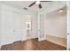 Bedroom featuring hardwood floors, a ceiling fan, and ensuite bathroom with glass door at 511 Roanoke St, Dunedin, FL 34698